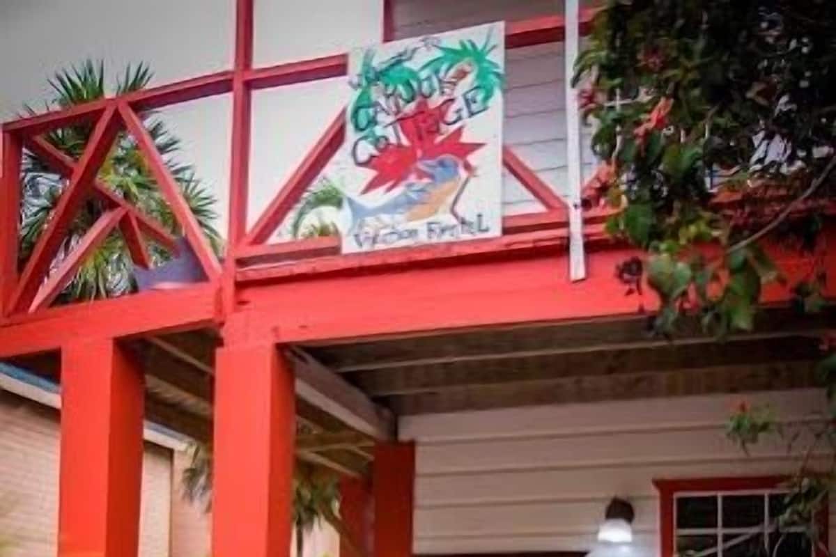 A building with a red and white facade, a sign with a dragon logo, and a tiled entrance area.