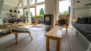 Un salon chaleureux avec un plancher en bois, une cheminée et un canapé agrémenté de coussins décoratifs.