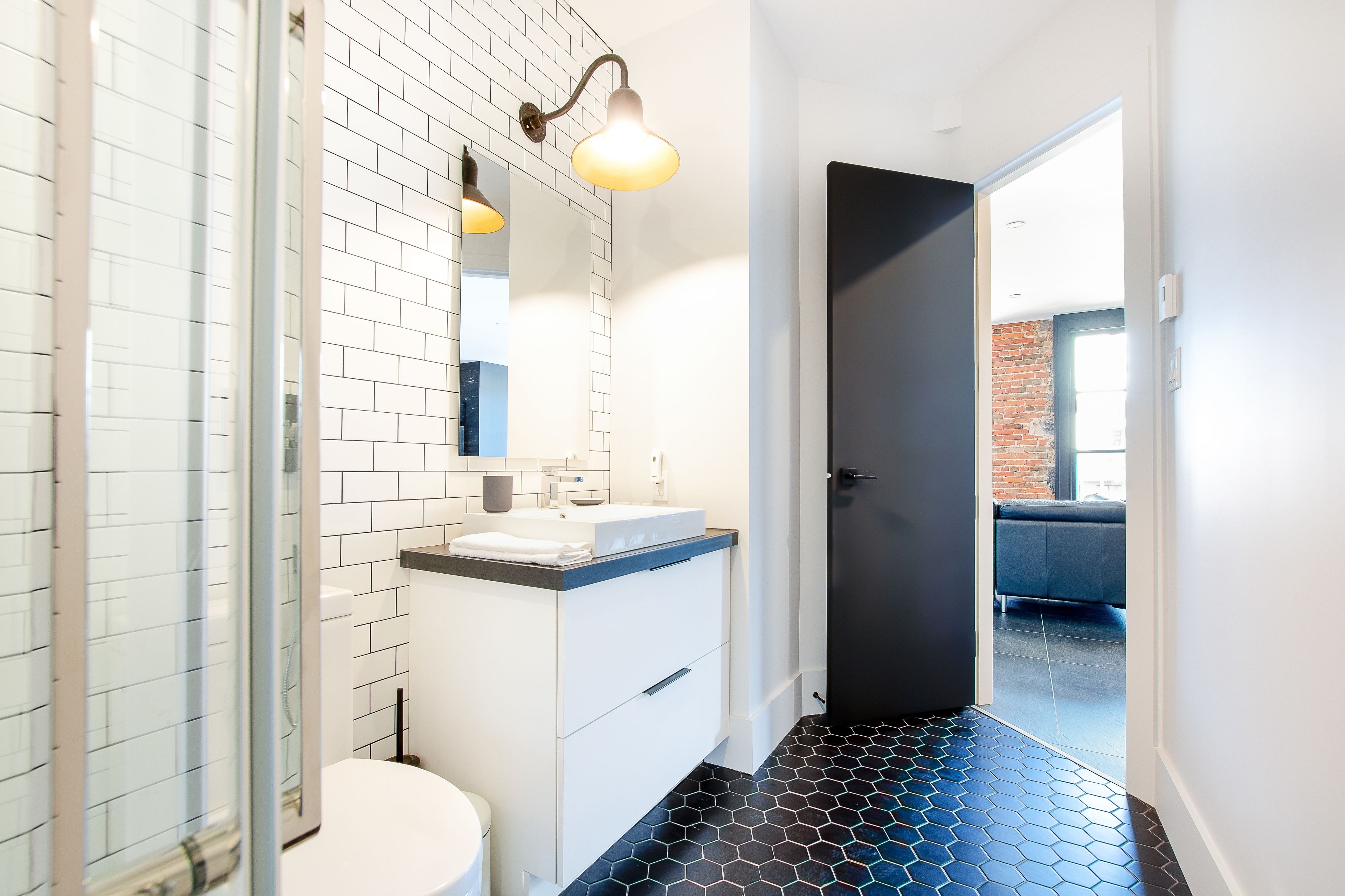 Une salle de bain moderne avec un lavabo blanc, un miroir et une douche.