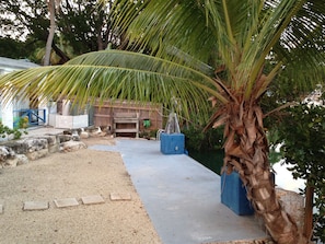 Guests can enjoy a tranquil outdoor space with a palm tree and a wooden structure.