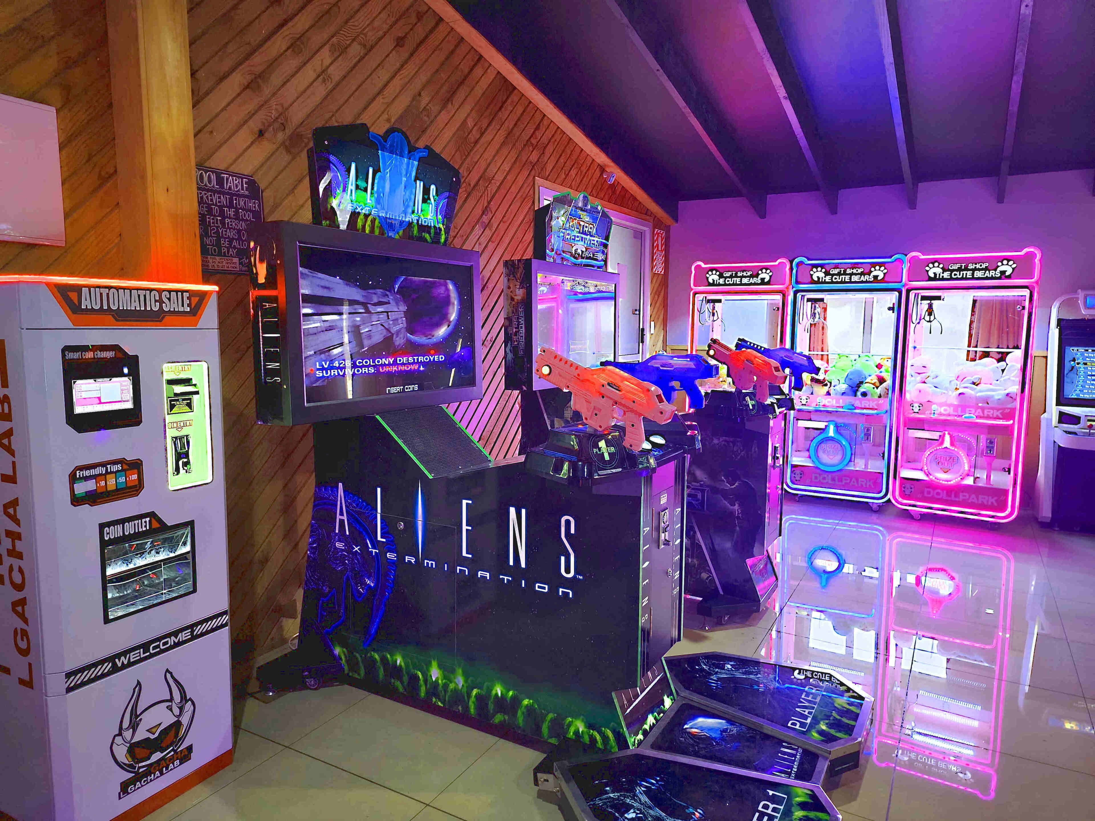 A gaming arcade with various machines including claw games and a space-themed game.