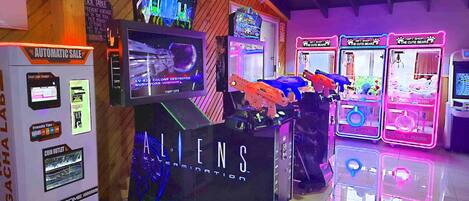 A gaming arcade with various machines including claw games and a space-themed game.