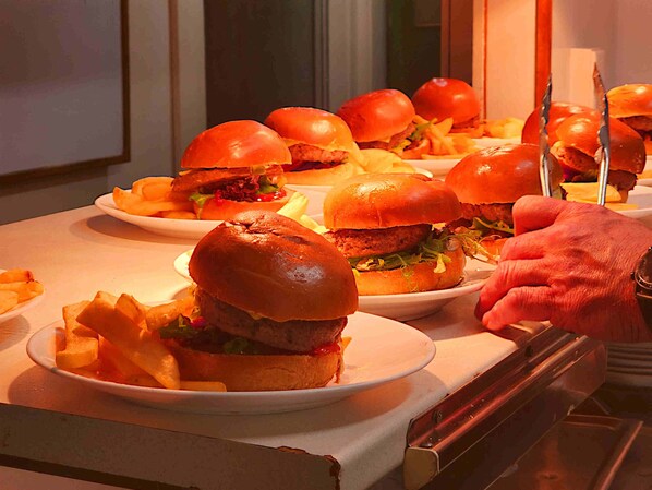 A buffet table with plates of burgers and fries.