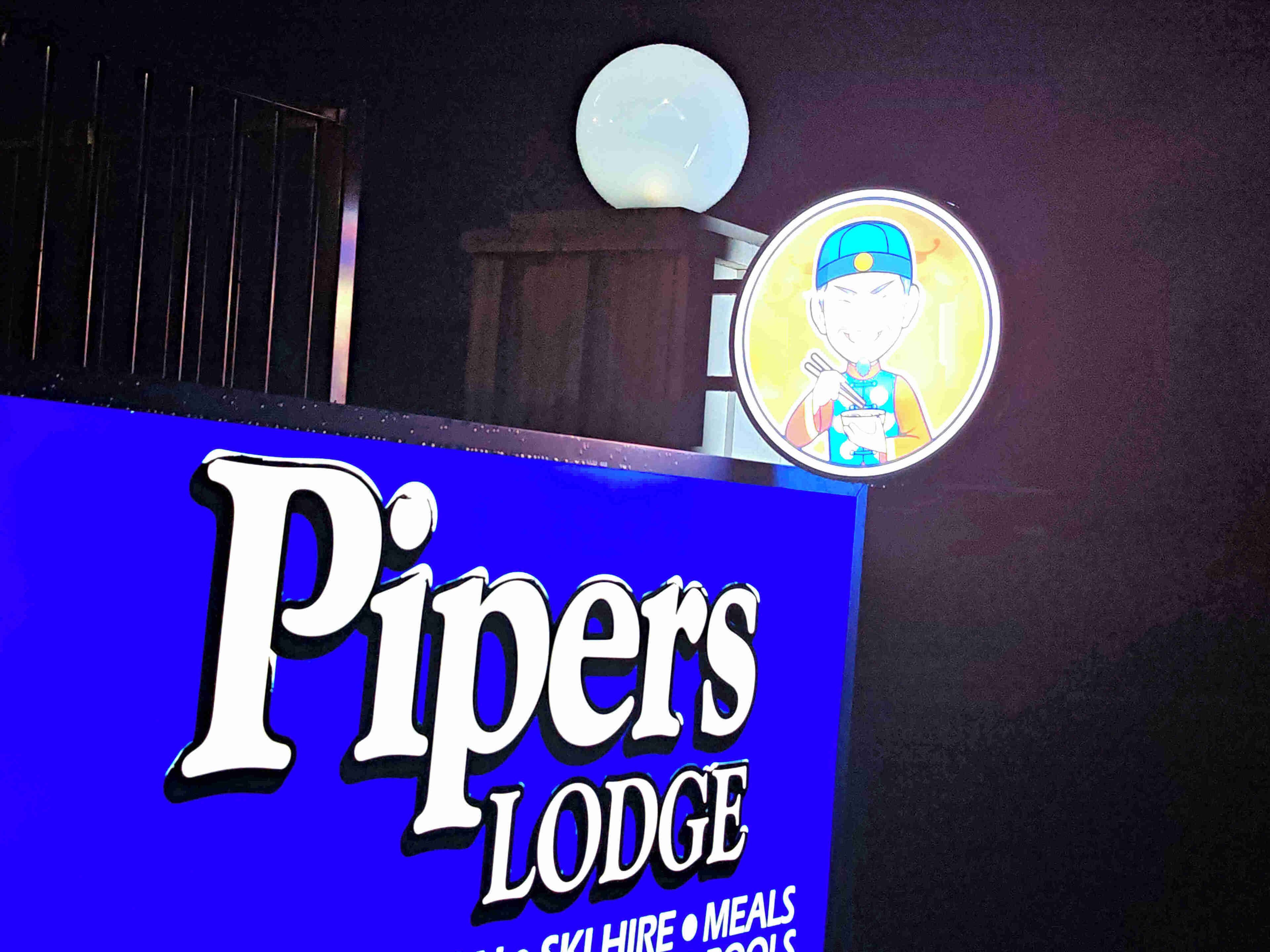 A sign for Pipers Lodge with a cartoon character.