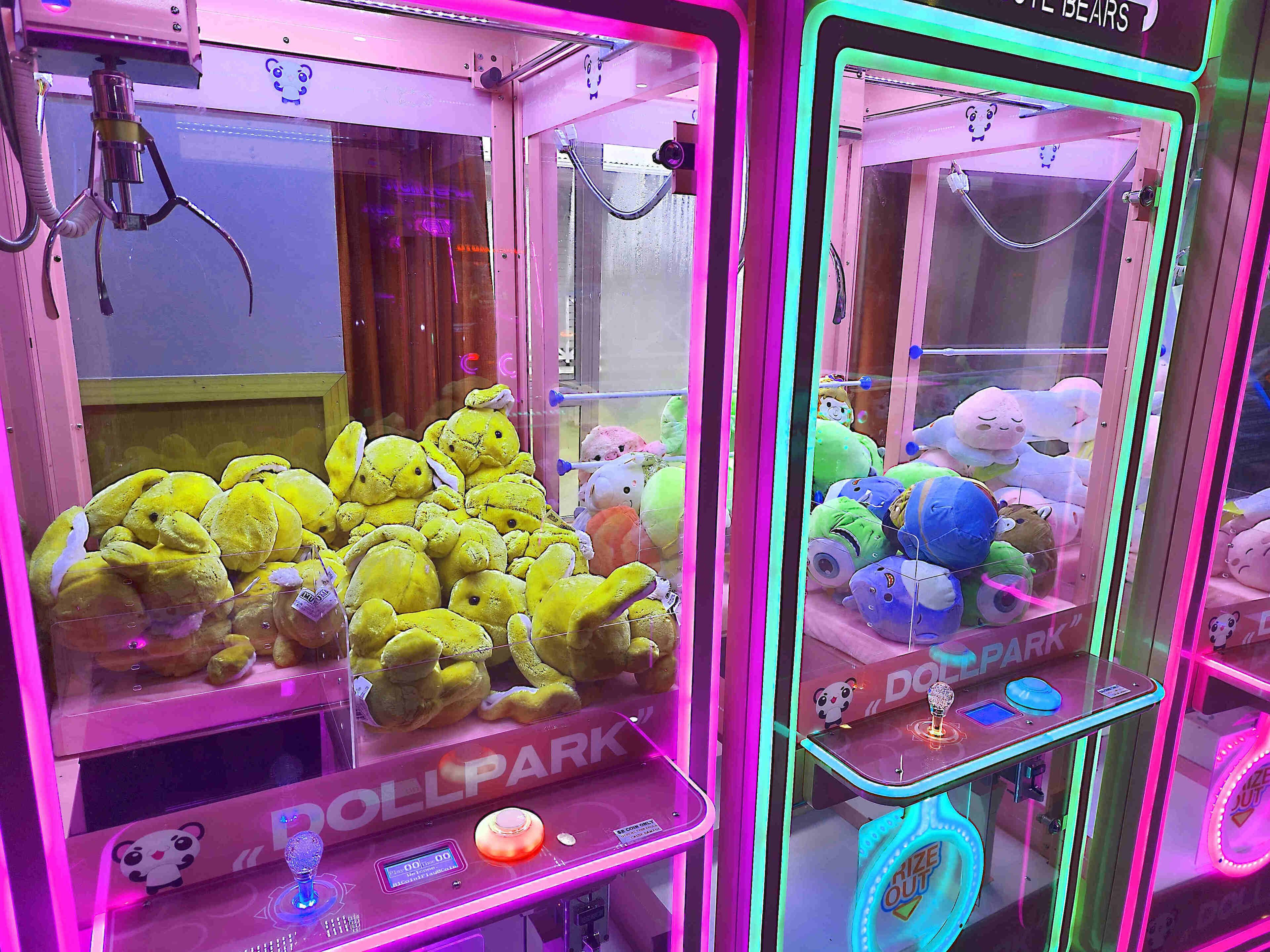 Two claw machines filled with plush toys.
