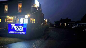 Vista frontal de la propiedad por la tarde o noche