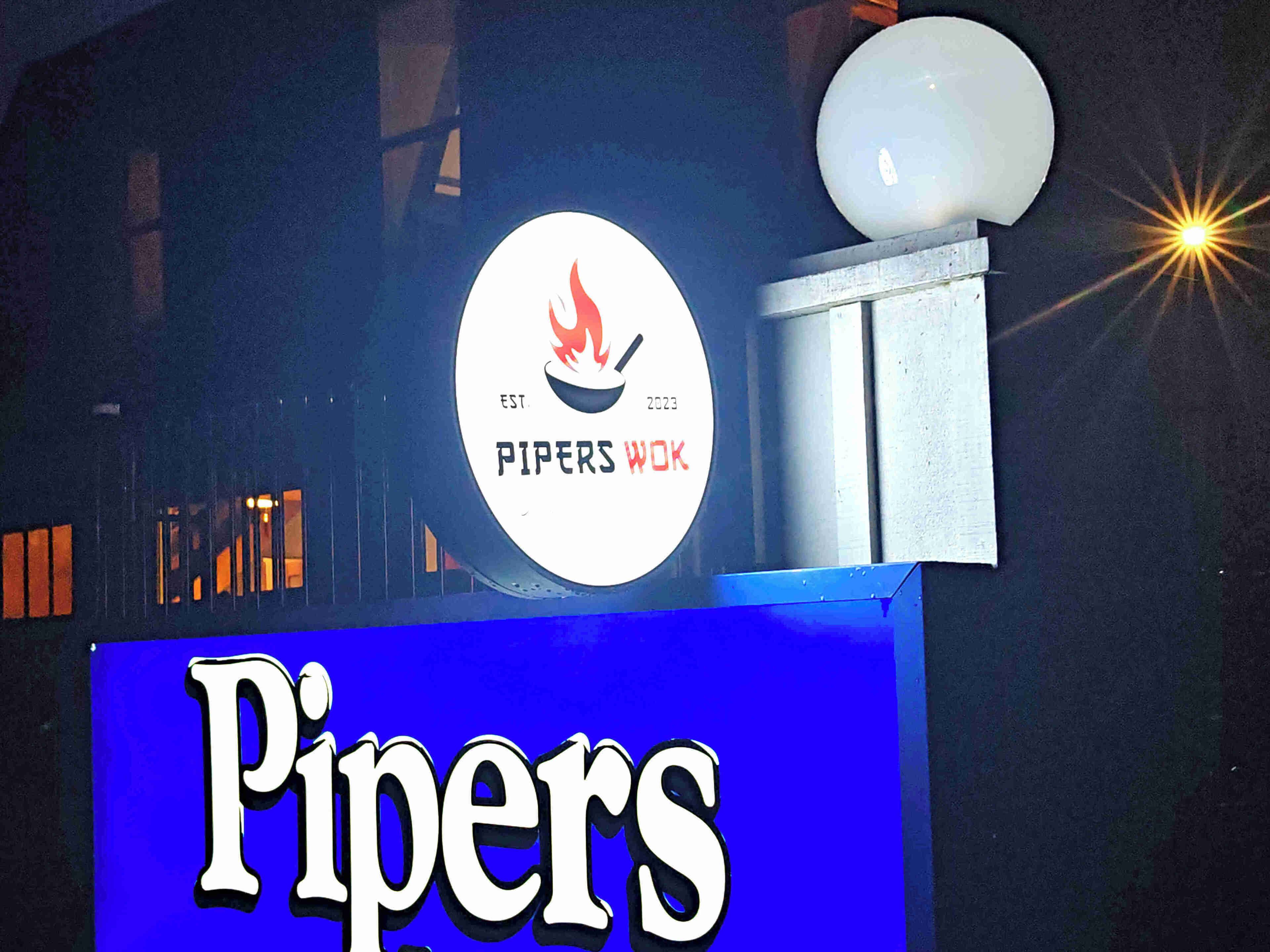 A sign for 'Pipers' with a logo featuring a flame and the year 2023.
