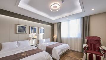 Habitación de hotel con dos camas, una silla de masaje y obras de arte en la pared.