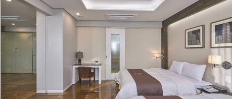 A modern hotel room with two beds, a desk, and a shower area.