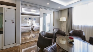 Une chambre d’hôtel avec un lit, un bureau, une chaise, une table et une lampe.