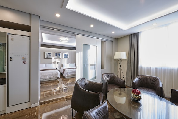 Una habitación de hotel con cama, escritorio, silla, mesa y lámpara.