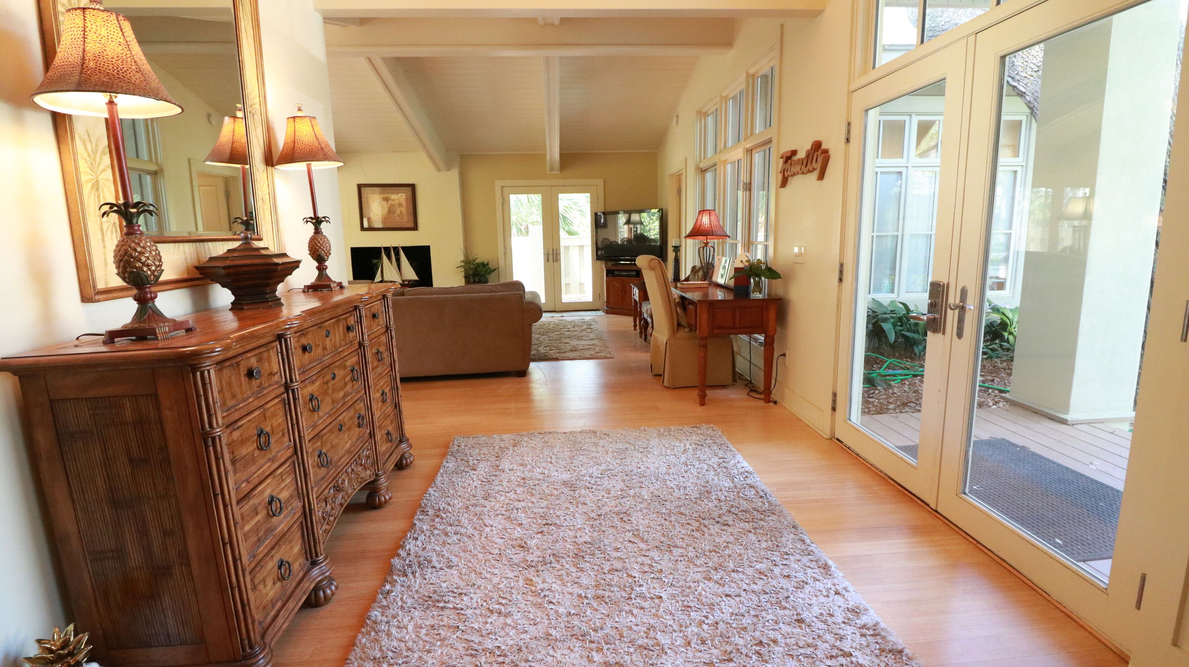 Un salon spacieux avec une commode en bois, un canapé et un coin repas.