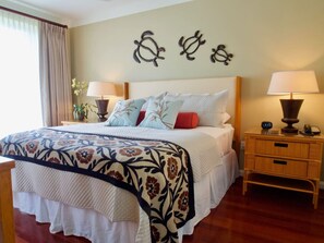 A neatly arranged bedroom with a large bed, two bedside tables, and decorative wall art. - Beautiful Ocean View on Quiet Side of Honua Kai (Lahaina)