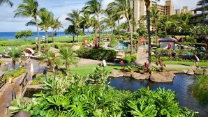 Ein Resort mit Pool, Palmen und Meerblick.