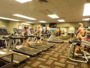 A gym with treadmills, stationary bikes, and exercise equipment.