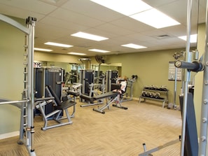 Une salle de sport équipée de divers appareils d’entraînement, notamment des machines à poids et des poids libres.