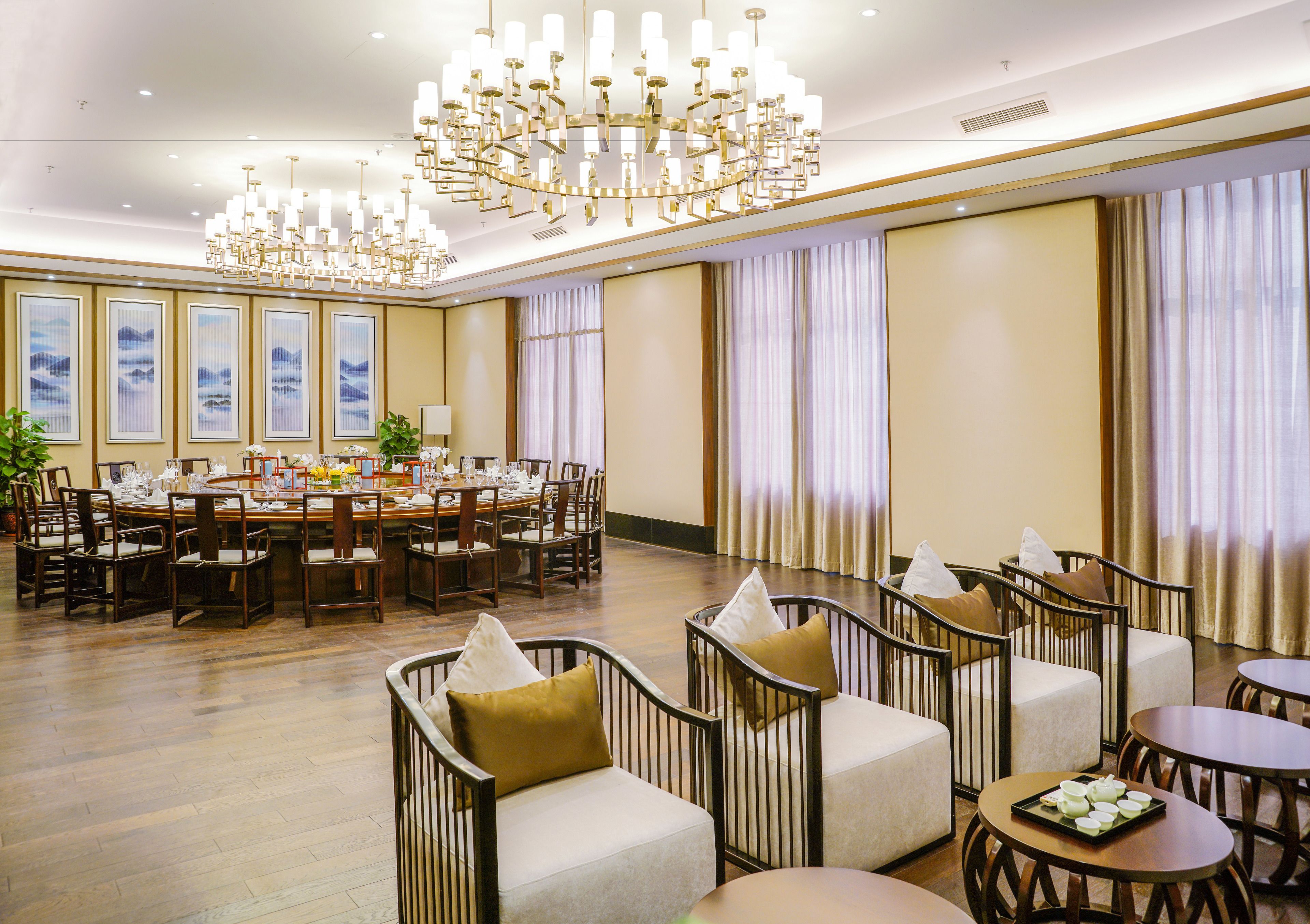 Un amplio vestíbulo de hotel con un amplio comedor, asientos cómodos y elegantes candelabros.