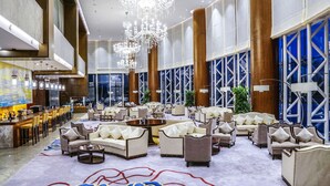 A spacious lobby with high ceilings, large chandeliers, and a bar area. - Qingshan Hotel Baotou（Yingbin Building） (Baotou)