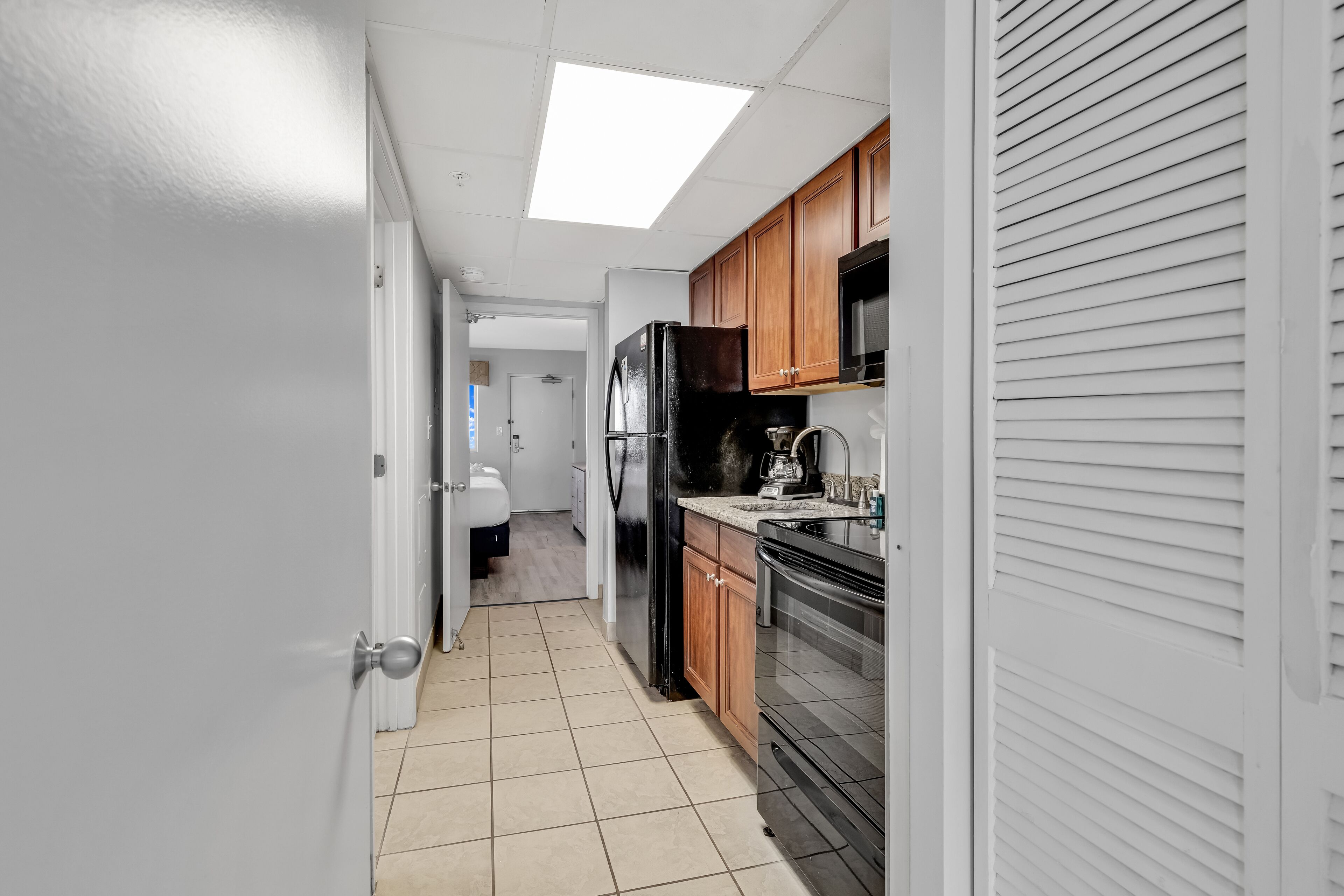 A kitchen with a refrigerator, stove, microwave, and wooden cabinets.