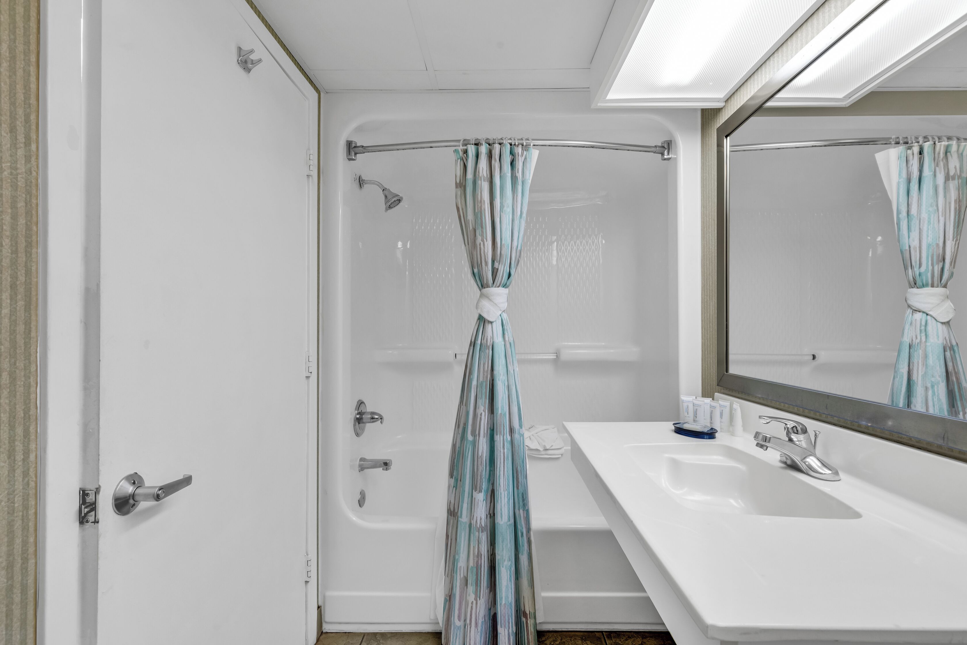 Une salle de bain avec une douche, un lavabo et un miroir.