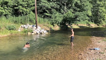 Un río de aguas cristalinas, rodeado de rocas y follaje.