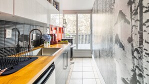 A modern kitchen with a wooden countertop, a black backsplash, and a large window overlooking a balcony. - Boutique Penthouse Designer 1 BR Suite w/2 Balconies in Downtown Toronto (Toronto)