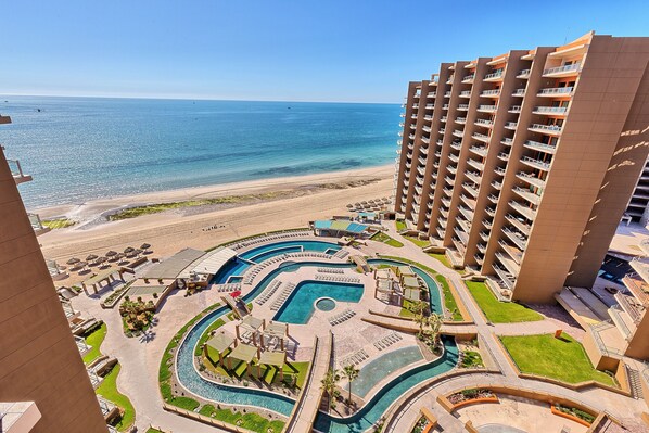 Un hôtel de grande hauteur doté d’une piscine, offrant une vue sur la plage et comprenant de nombreux balcons.