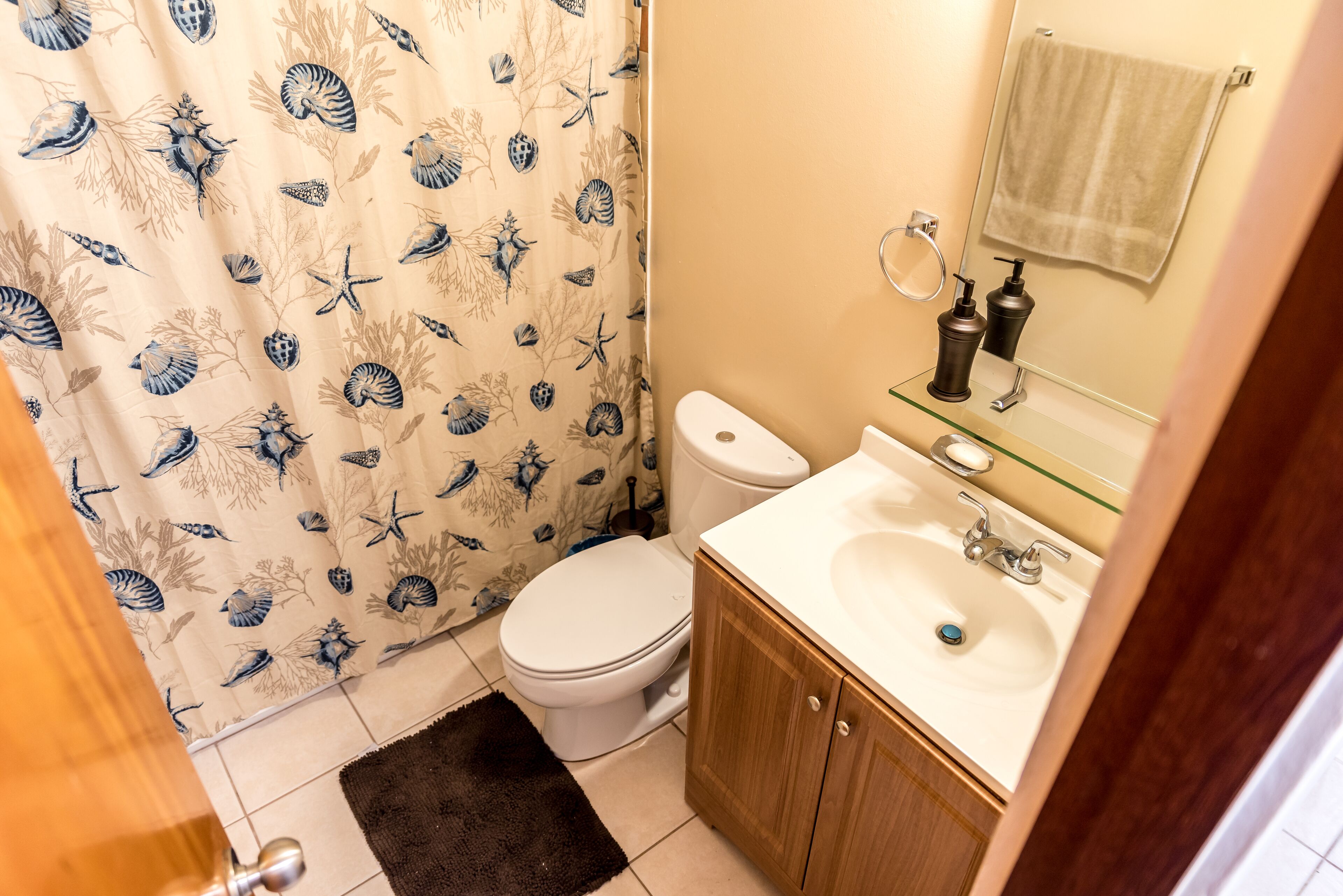 A bathroom with a toilet, sink, and mirror.