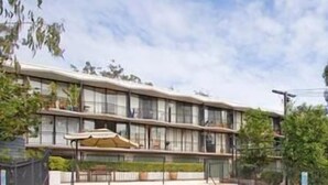 A modern hotel with a swimming pool, outdoor seating, and a covered patio area. - Riverpark-studio apartment (Highgate Hill)