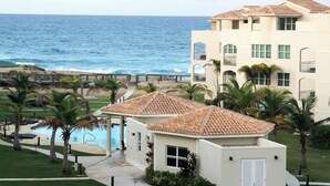 Ein Strandhotel mit Schwimmbad, Palmen und Blick auf den Ozean.