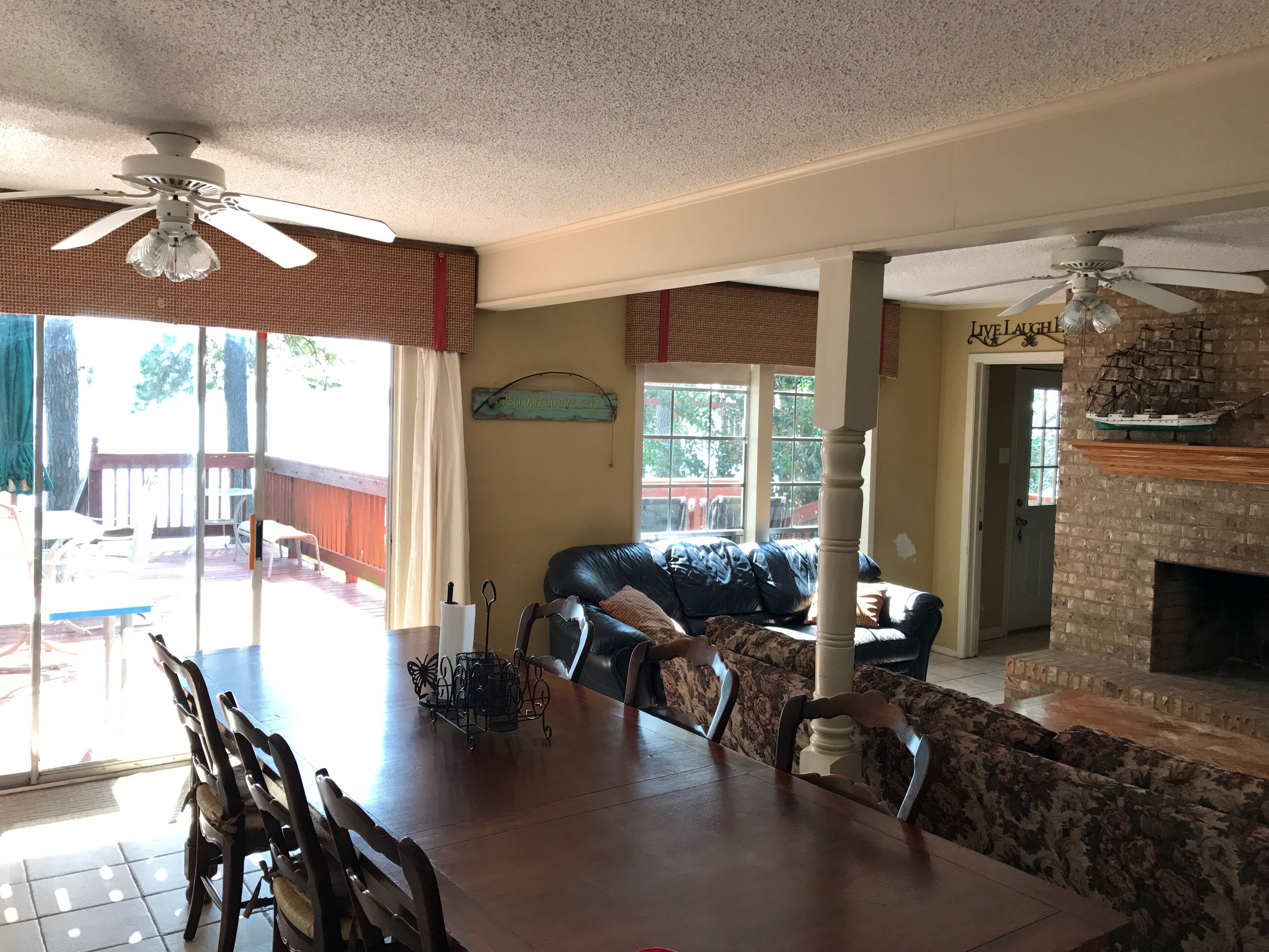 Un comedor con una mesa y sillas de madera, una chimenea y un ventilador de techo.