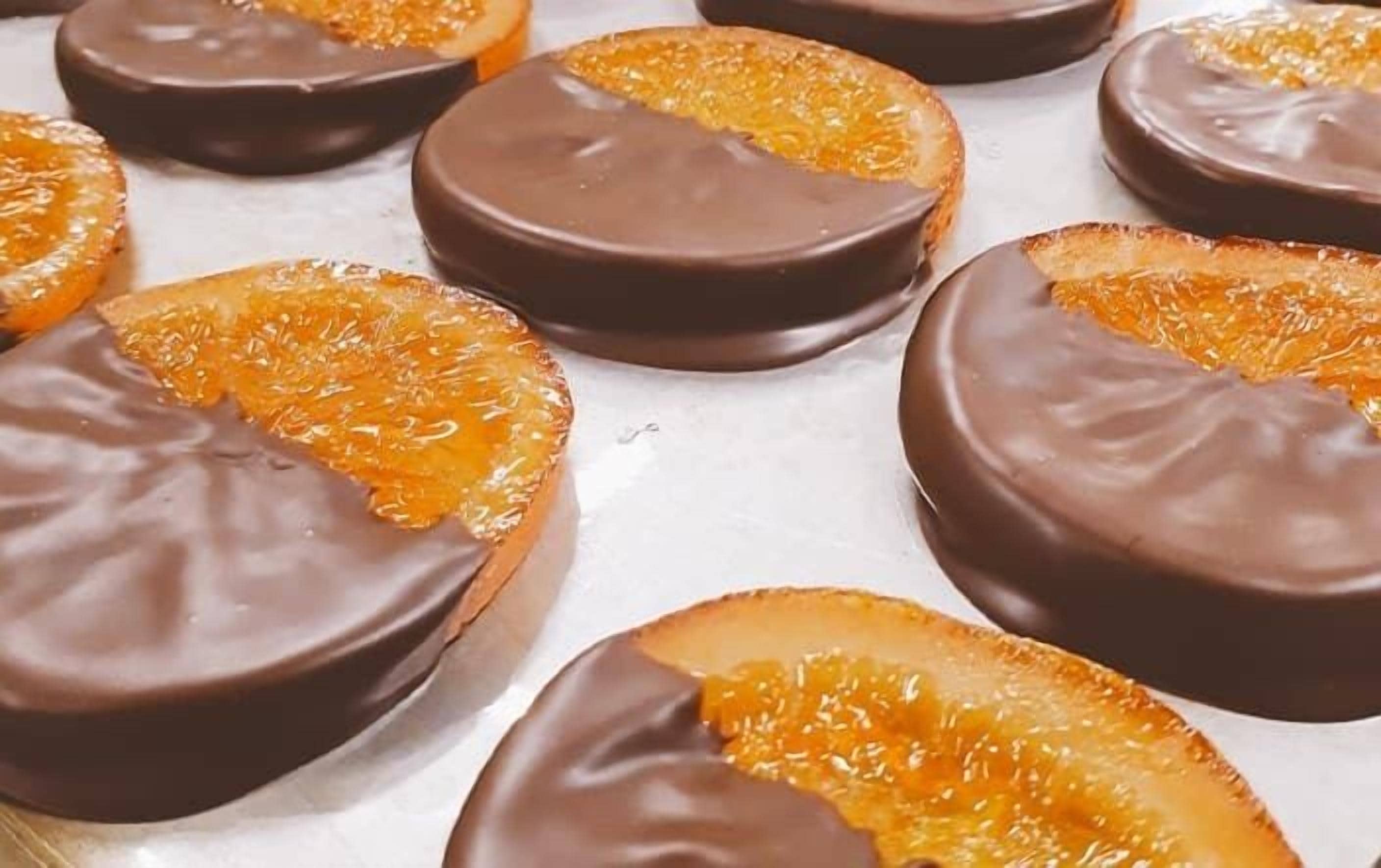 Een schaal met chocoladebedekte sinaasappelschijfjes.