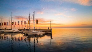 A marina with boats docked at a pier during sunset. - Residence Don - pool, garden, 200m to the lake (Bardolino)