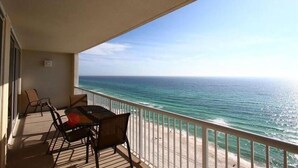 A balcony with a table and chairs overlooking the ocean. - Family Beach Spot, Huge Balcony,4BR/3BA, 4 pools,top-notch exercise room, Tennis (Panama City Beach)