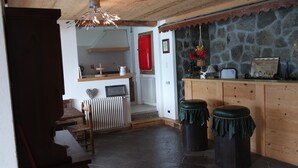 A cozy kitchen with a stone wall, wooden counter, and a red refrigerator. - Charming apartment with stunning views of Lake Como (Vestreno)