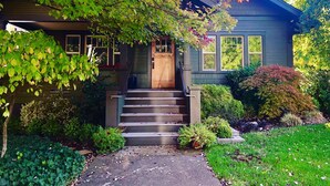 A house with a front porch, steps, and a small garden area with various plants. - Titania - Second Spring Property 1-3 Bedroom Luxury Rentals In Downtown Ashland (Ashland)