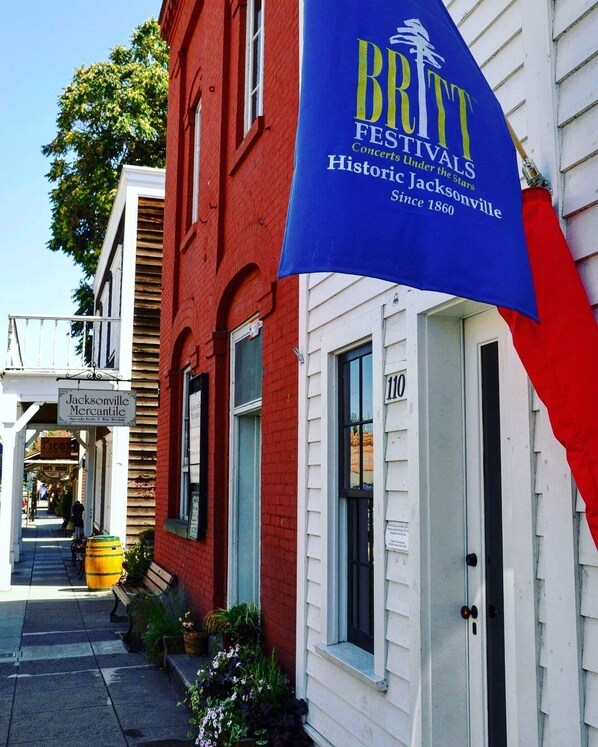 A building with a blue banner advertising 'BRITT FESTIVALS' and a sign for 'Jacksonville Mercantile'.
