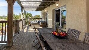 A wooden deck with a table and chairs, a bowl of fruit, and a view of the surrounding landscape. - 4* Gallery Villa in Moliets, 15 p, heated pool, ensuite rooms/ close 2 beach (Moliets-Et-Maa)