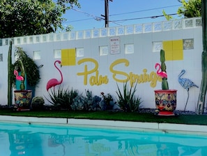 A pool area with a sign that reads "Palm Springs" and decorative flamingos. - Where LOVE Meets LUXURY: YOUR Mid-Century Escape!
"An UNFORGETABLE EXPERIENCE!" (Palm Springs)