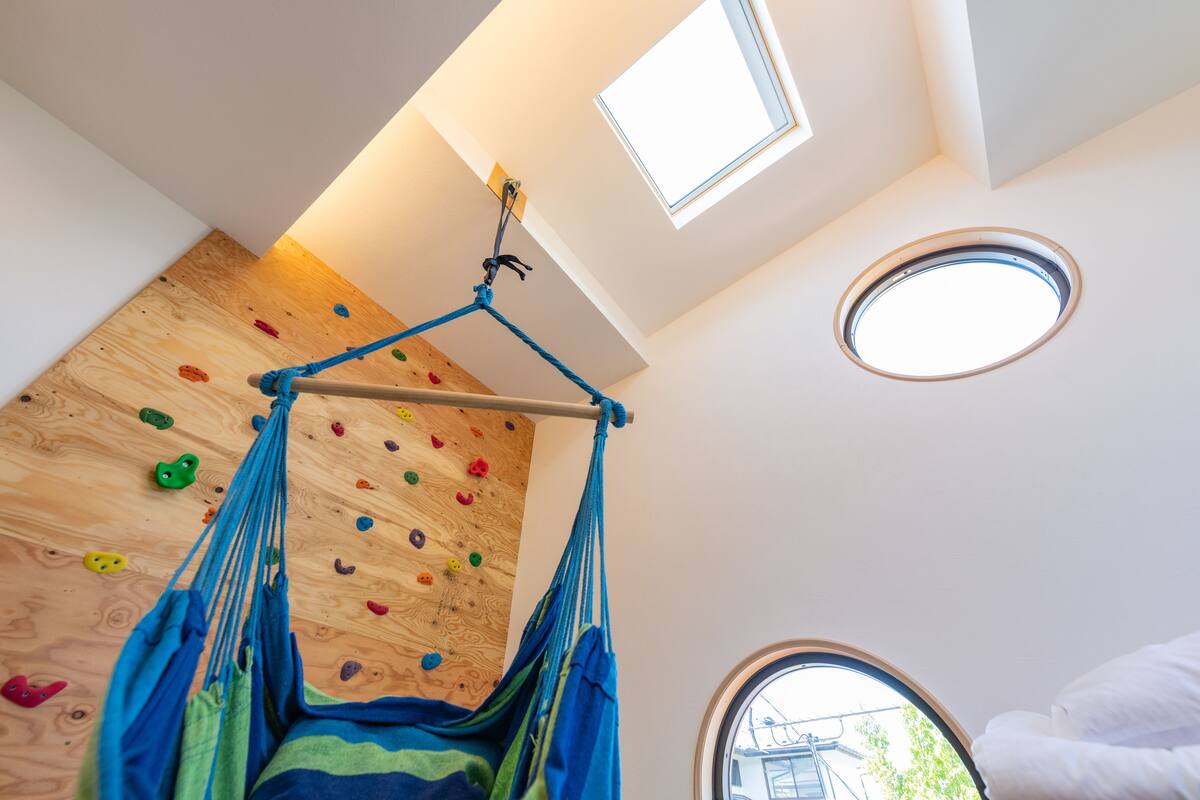 A room with a climbing wall, a hammock, and skylights.