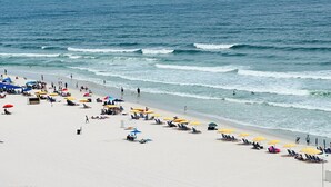 A beach with rows of sun loungers and umbrellas, a sandy shore, and the ocean. - ROMANTIC MALIBU ELEGANCE - on HGTV & DIRECTLY on the LUMINOUS GULF SAND! (Orange Beach)