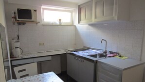 A compact kitchen with a microwave, coffee maker, and a window above the sink. - Between Breisach and Staufen (Bad Krozingen)