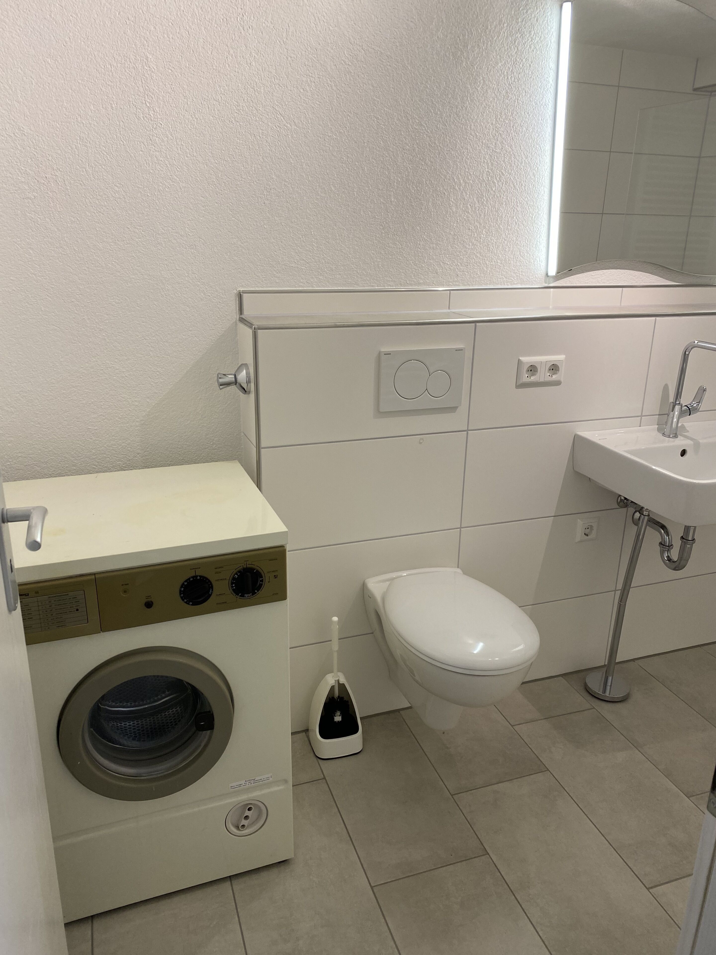 Een bad/douchecombinatie, een haardroger, handdoeken