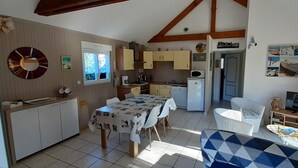 Une cuisine compacte avec un coin repas, un téléviseur et une planche de surf.