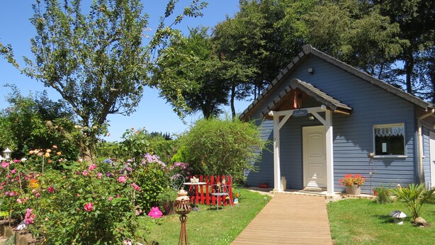 Une maison bleue avec une terrasse en bois donnant sur un porche.
