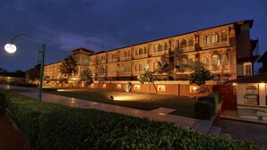 A large, ornate building with multiple balconies and a well-lit entrance. - Gateway Kandla Gandhidham (Anjar)