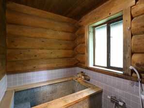 A wooden cabin bathroom with a bathtub, a window, and tiled walls. - Campagne Hakuba (Hakuba)