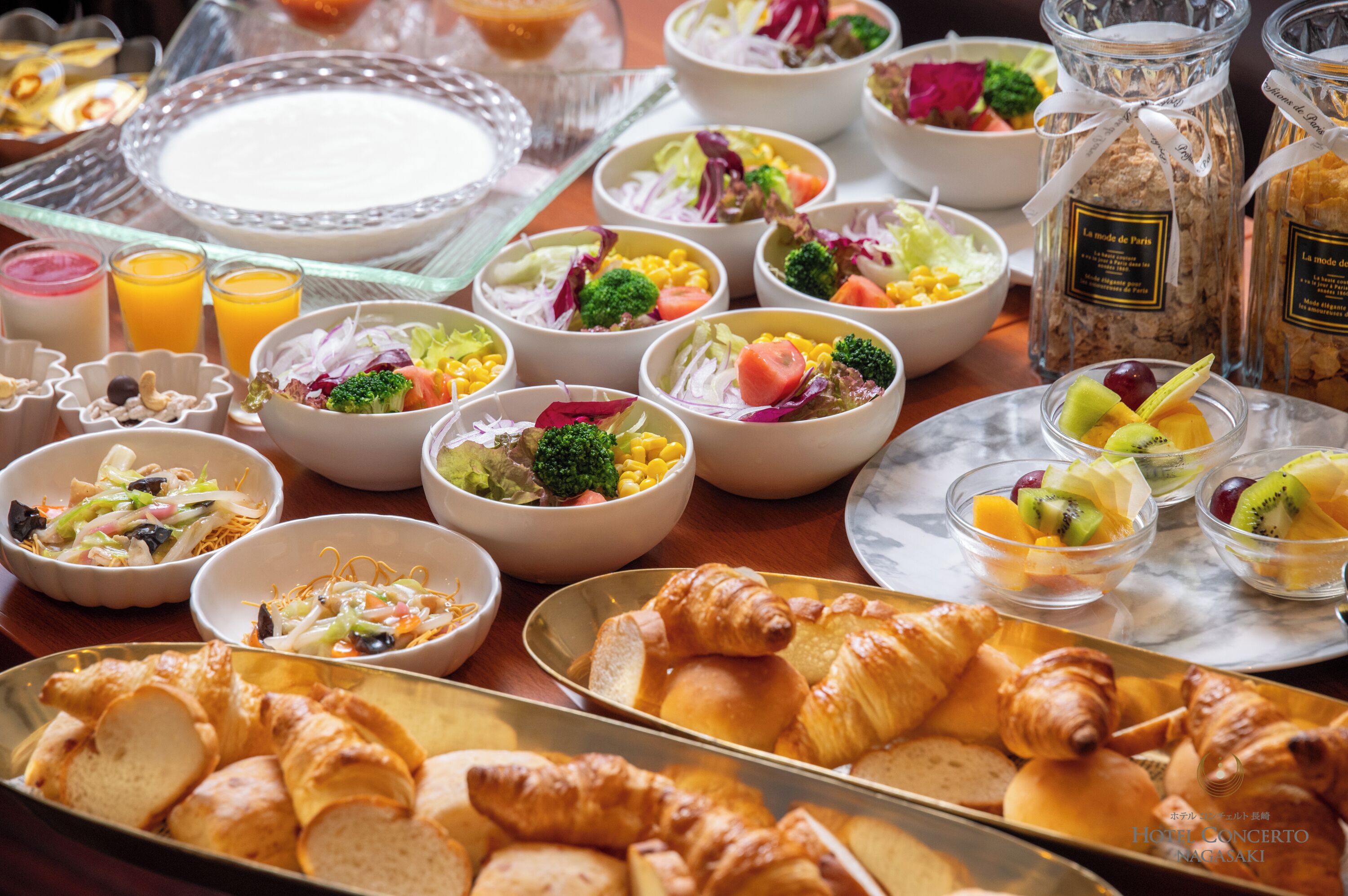 Een ontbijtbuffet met diverse gerechten, waaronder salades, fruit en gebak.