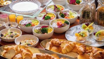Een ontbijtbuffet met diverse gerechten, waaronder salades, fruit en gebak.