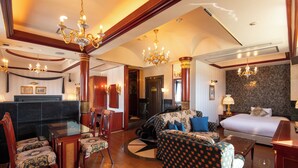 Une chambre d’hôtel comprenant un grand lit, un canapé, une table à manger avec des chaises et un comptoir de réception.